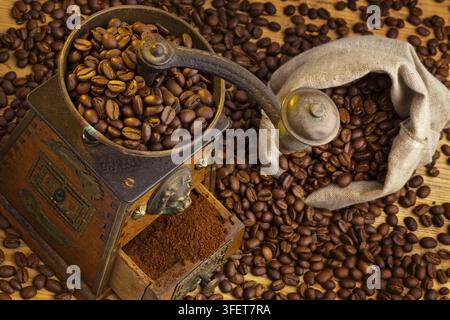 Many coffee beans lie next to a coffee grinder. Freshly ground coffee, studio recording, Federal Republic of Germany Stock Photo