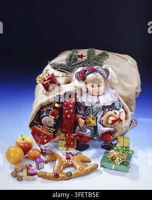 Christmas gifts, studio shot, gifts in a bag, Santa Claus, nuts, fruits, teddy bear, doll, Wilhelmshaven, Lower Saxony, Federal Republic of Germany Stock Photo