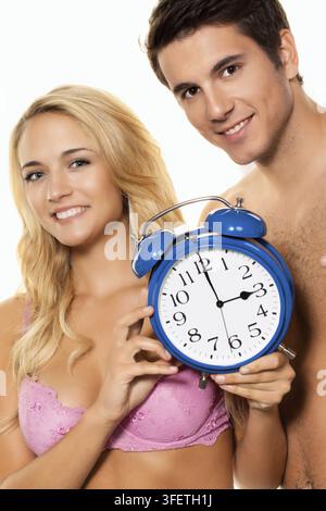 Time change, clock change, summertime, wintertime, couple with alarm clock, 25, 30, years, studio recording, Federal Republic of Germany Stock Photo