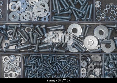 Close up of metal washers, bolts and nuts stored in a plastic tray Stock Photo