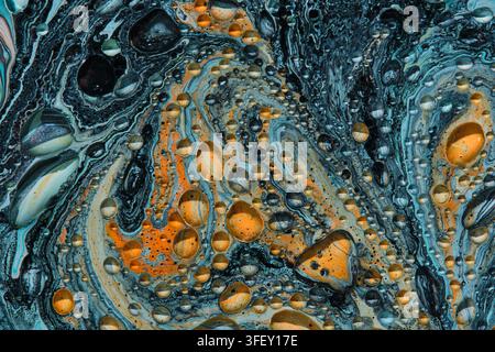 Top view macro pattern swirling dark blue, orange, and white fluid paint with circular cells Stock Photo