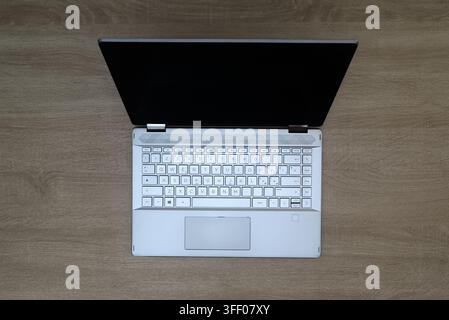 Top down flat lay of a modern laptop with a closed screen on a textured wooden office desk, copy space Stock Photo