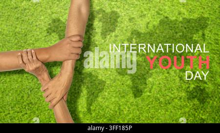 A banner celebrating International Youth Day, featuring three diverse hands locked in unity over a green grass background with a world map silhouette Stock Photo