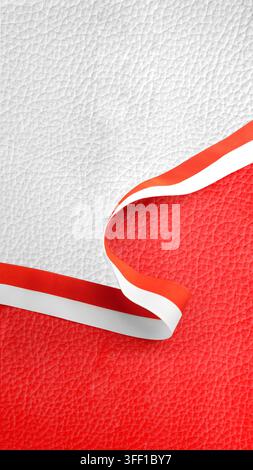 A vertical textured leather background in red and white colors, divided by a matching striped ribbon. Ideal for national day designs. Hari Kemerdekaan Stock Photo