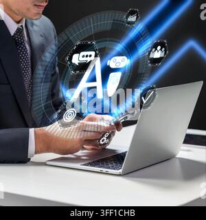 A professional businessman in a suit uses a mobile phone and laptop with a futuristic holographic interface showing AI chatbot, communication, and dig Stock Photo
