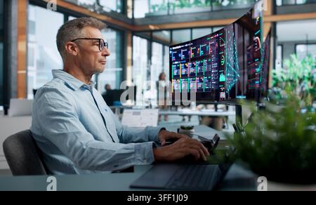 Data Scientist Carefully Analyzes Neural Network Models Using Dual Touchscreen Laptops. Stock Photo