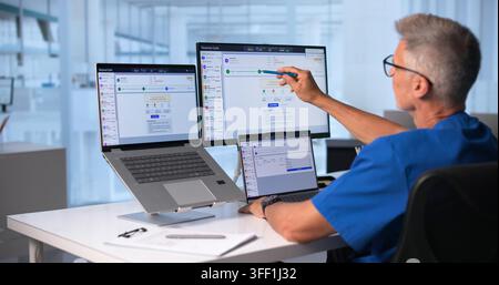 Healthcare Manager Carefully Reviews Medical Billing Codes On Laptop Screen. Stock Photo
