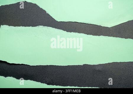 An abstract minimalist background featuring layered torn paper in mint green and textured black, creating a landscape-like composition Stock Photo