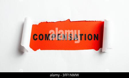 A conceptual image showing the word COMPENSATION printed on a bright red background, partially revealed by tearing through a white paper surface. Conc Stock Photo