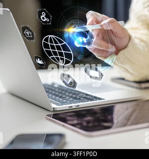 Person interacting with futuristic virtual cloud computing and global network icons using a stylus pen over a laptop. Concept of Remote working Stock Photo