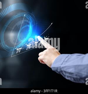 Businessman hand touching a futuristic virtual screen displaying growing e-commerce sales and shopping cart icons, symbolizing digital business growth Stock Photo