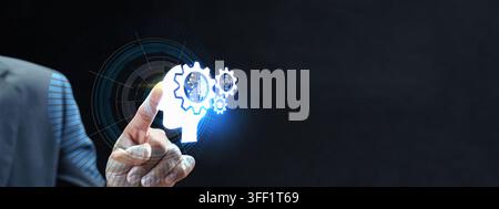 Businessman finger touching a glowing AI head icon with gears, symbolizing machine learning, cognitive technology, and digital innovation on a dark ba Stock Photo