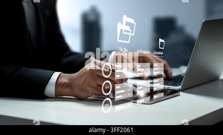 Businessman managing workflows on a digital tablet with virtual task management, to-do list, and progress tracking graphics. Management concept Stock Photo