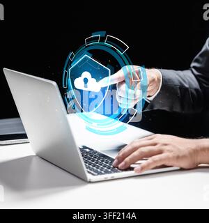 Businessman interacting with a futuristic glowing cloud security shield hologram on a laptop, representing data protection and cyber security. Concept Stock Photo