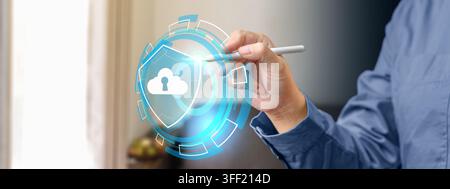 A business person interacting with a glowing digital hologram of a shield and cloud keyhole, representing cloud security and data protection. Concept Stock Photo