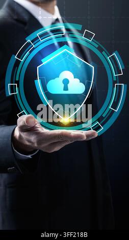 Businessman holding glowing holographic shield with cloud and keyhole icon, representing advanced cloud computing security and data protection. Concep Stock Photo