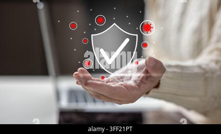 Hand holding a digital shield with a checkmark protecting against floating red virus icons, representing antivirus security and health defense. Concep Stock Photo