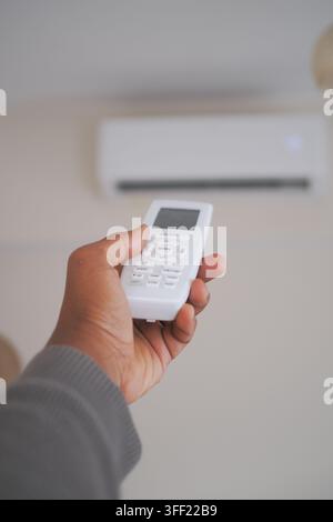 Person using AC remote control Stock Photo