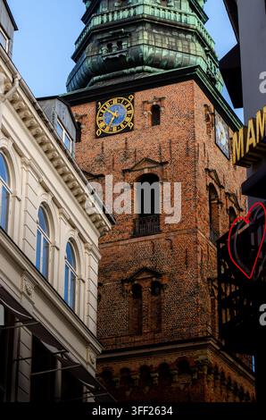 Low-angle view of the historic clock tower at Nikolaj Kunsthal (former St. Nicholas Church) in central Copenhagen. Stock Photo