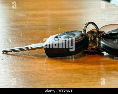 Riga, Latvia - September 3, 2026: Close-up of car keys and a key ring resting on a wooden table, highlighting everyday transportation, vehicle ownersh Stock Photo