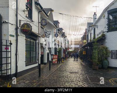 Glasgow, Scotland, United Kingdom - 22 November 2025: View of Ashton Lane with cobblestone street, historic white buildings, hanging fairy lights, and Stock Photo