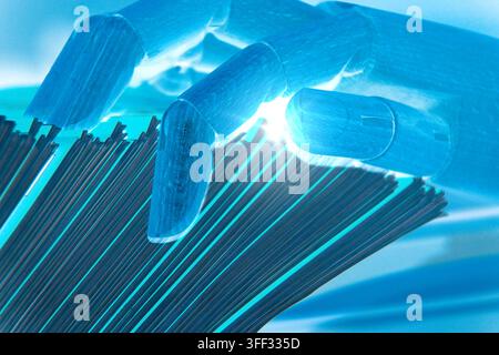 Robotic hand looking for a specific sheet among multiple office documents, illustrating AI technology, automated tasks, information management, digita Stock Photo