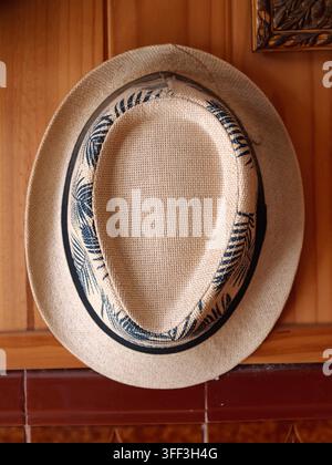 Beige woven straw panama hat featuring a stylish blue and white tropical palm leaf pattern band, symbolizing summer, leisure, and travel on transparen Stock Photo