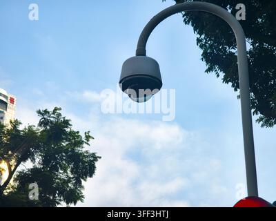 outdoor security surveillance camera mounted on a curved metal pole, Singapore Stock Photo
