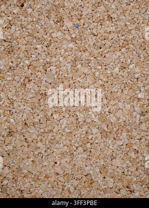 Close up natural light brown corkboard surface showing granular recycled fiber texture, warm rustic backdrop ideal for backgrounds, design elements, a Stock Photo