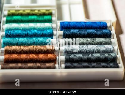Macro close up of colorful spools of sewing thread arranged together, vibrant colors, textile materials, background. Stock Photo