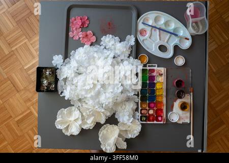 Complete overhead watercolor and flower crafting setup on a gray studio table Stock Photo