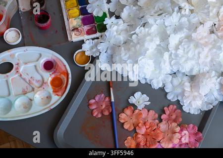 White flower arrangement with watercolor palette and painted blossoms on gray background Stock Photo