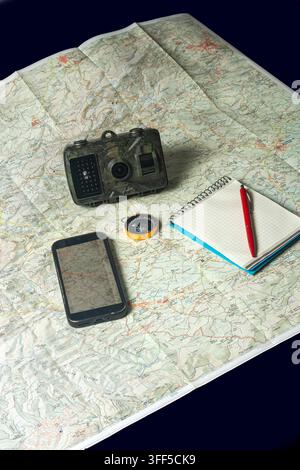 Navigating wilderness with map, camera, smartphone, and compass Stock Photo