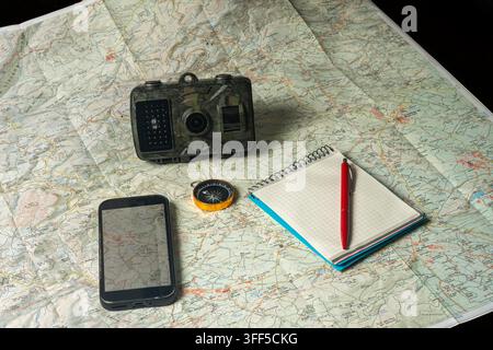 Planning outdoor adventure using map, compass, trail camera Stock Photo