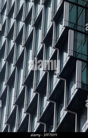 A highly geometric and repetitive pattern on a modern office building facade. Stock Photo