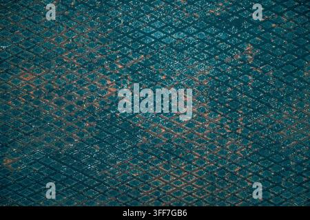 Heavily weathered teal diamond plate metal surface with raised checker pattern, rust patches, and rough texture, top view Stock Photo
