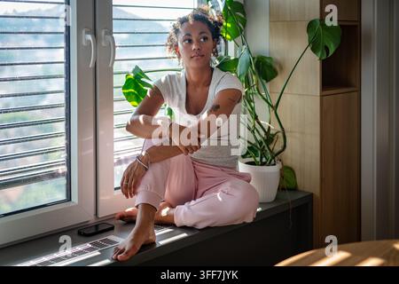 Female diabetes patient with CGM sensor in bright apartment Stock Photo