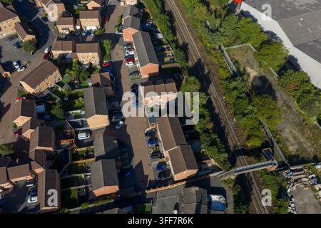 Top down aerial view of a Castleford residential estate in Yorkshire beside railway tracks showing rows of brick houses parked cars gardens roads tree Stock Photo
