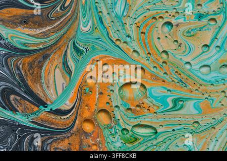 Colorful fluid art macro with dark swirls, bright orange paint, turquoise wave patterns, and cells Stock Photo