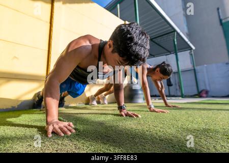 Young athletic man and woman doing push ups Stock Photo