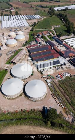 Aerial view of large greenhouses with a circular water tank and solar ...