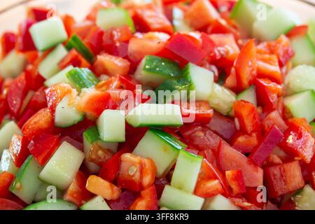 Fresh, vibrant, chopped red bell pepper and cucumber salad Stock Photo