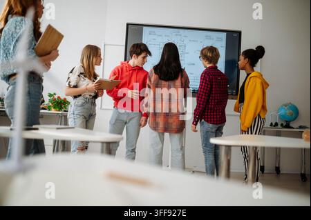 High school students collaborating on engineering project using interactive display. Stock Photo