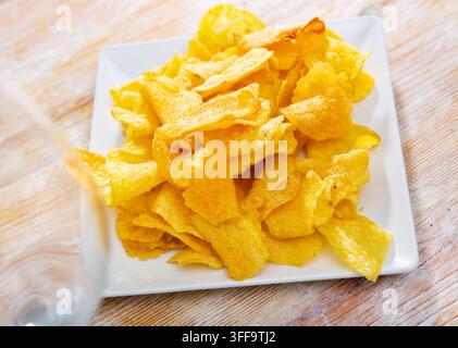 Crispy salty potato chips with natural taste on plate Stock Photo