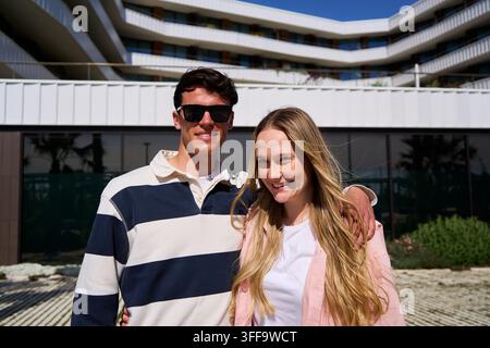 Happy young couple posing at modern hotel building Stock Photo