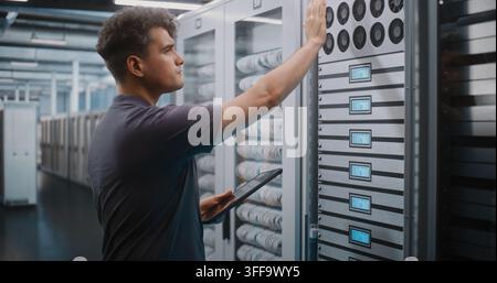 IT Specialist Holds Digital Tablet and Uses Keys to Open Glass Server Cabinet Door Inspect Cooling Fans and Hardware Components. System Diagnostics, Physical Maintenance Ensure Optimal Server Airflow. Stock Photo