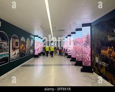 Passengers Walking Through Copenhagen Airport Advertising Corridor.  Stock Photo