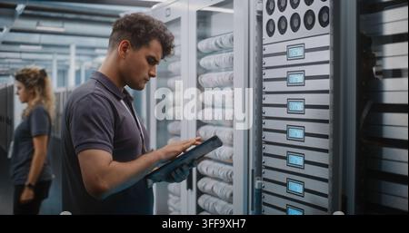 IT Specialist Holds Digital Tablet and Uses Keys to Open Glass Server Cabinet Door Inspect Cooling Fans and Hardware Components. System Diagnostics, Physical Maintenance Ensure Optimal Server Airflow. Stock Photo