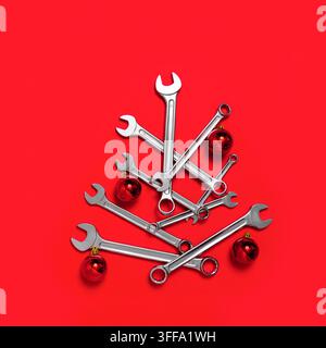Christmas tree made of wrenches decorated with balls on a red background. New Year banner with tools. Postcard with place for greeting text for happy Stock Photo