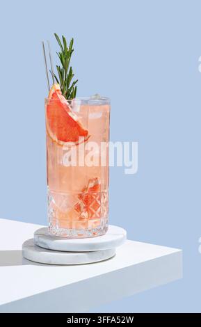Refreshing drink with grapefruit and rosemary in a glass on a wooden ...